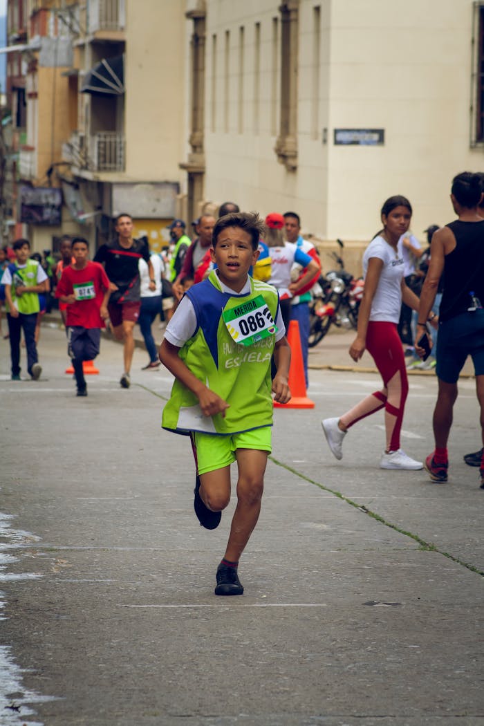 Energetic kids participate in a street race marathon in a vibrant urban neighborhood in Venezuela.